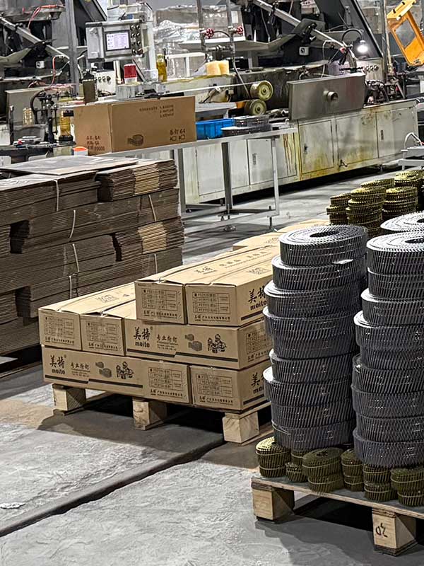 Nail coils and labeled cartons arranged on pallets beside packing equipment